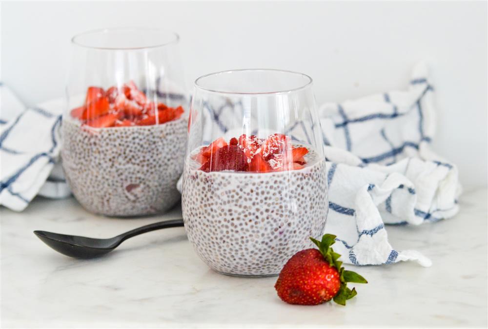 Two glasses of chia pudding with cream and strawberries